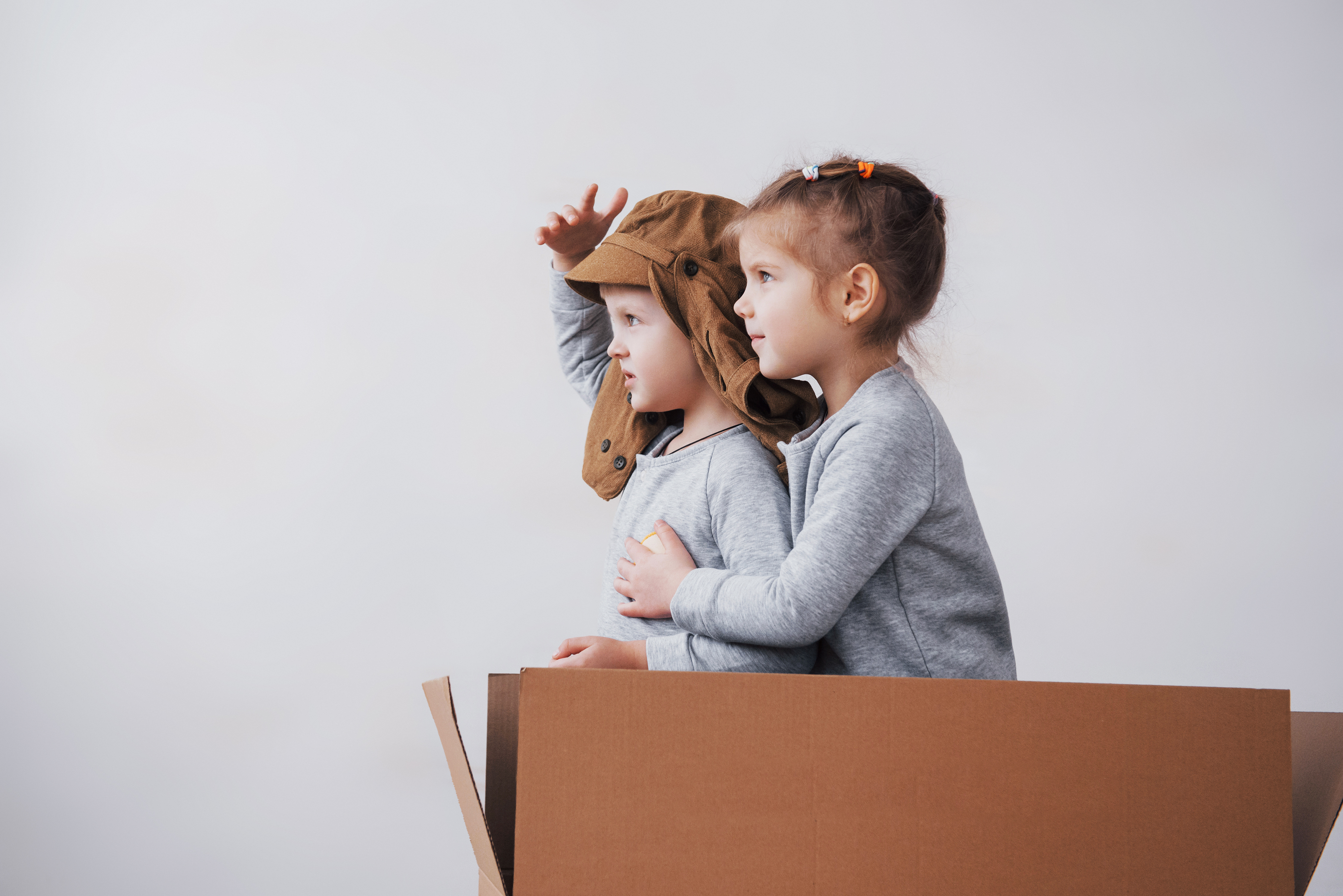 dwie dziewczynki bawiące się w kartonowym pudle